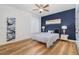 Bedroom with a blue accent wall, wood-look floors, and contemporary decor and ceiling fan at 14346 San Domingo Blvd, Port Charlotte, FL 33981