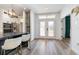 Bright foyer featuring double doors, hardwood flooring, and an open view into the adjacent kitchen at 14346 San Domingo Blvd, Port Charlotte, FL 33981