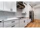 Modern kitchen with white cabinets, black hardware, stainless steel appliances, and a stylish backsplash at 14346 San Domingo Blvd, Port Charlotte, FL 33981