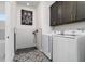 A stylish laundry room features a dog washing station, patterned floor, and a modern washer and dryer at 14346 San Domingo Blvd, Port Charlotte, FL 33981
