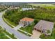 Stunning aerial shot of the property, showcasing the tile roof, landscaping, and neighborhood pond at 32924 Estate Garden Dr, Wesley Chapel, FL 33545