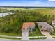 Aerial view of property with a tile roof, landscaping, and proximity to green spaces and airfield at 32924 Estate Garden Dr, Wesley Chapel, FL 33545