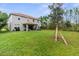 Expansive backyard view featuring a well-maintained lawn, patio, and the home's exterior at 32924 Estate Garden Dr, Wesley Chapel, FL 33545