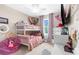Bright bedroom with a bunk bed, light pink accents, and carpeted floors at 32924 Estate Garden Dr, Wesley Chapel, FL 33545