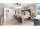 Spacious bedroom featuring a large bed, neutral decor, ceiling fan, and ample natural light from the window at 32924 Estate Garden Dr, Wesley Chapel, FL 33545