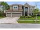 Stunning two-story home with red tile roof, three-car garage and brick-paved driveway at 32924 Estate Garden Dr, Wesley Chapel, FL 33545