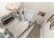 Bright foyer boasts chandelier, dining space, and stairway with wood railing and white risers at 32924 Estate Garden Dr, Wesley Chapel, FL 33545