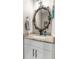 Charming half bathroom vanity with marble counter and decorative mirror at 32924 Estate Garden Dr, Wesley Chapel, FL 33545