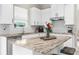 Bright kitchen featuring white cabinets, stainless steel appliances, and marble countertops at 32924 Estate Garden Dr, Wesley Chapel, FL 33545