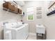 Bright laundry room with white washer and dryer, overhead shelving and a utility sink at 32924 Estate Garden Dr, Wesley Chapel, FL 33545
