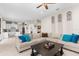 Open-concept living room featuring an oversized couch with blue pillows, light colored floors, and modern decor at 32924 Estate Garden Dr, Wesley Chapel, FL 33545