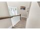 Carpeted staircase with white spindles and dark wood railing leading to the upper level of the home at 32924 Estate Garden Dr, Wesley Chapel, FL 33545