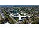 Wide aerial view showing the property within a lush community with pond and mature trees at 5820 43Rd N Ter # 1406, St Petersburg, FL 33709