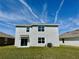 View of the back of the home with a grassy lawn and sliding glass door at 8926 Forge Breeze Loop, Wesley Chapel, FL 33545