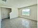 Neutral toned living room featuring tile floors and a window with natural light at 8926 Forge Breeze Loop, Wesley Chapel, FL 33545