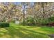 Expansive backyard with lush greenery, mature trees, and a storage shed, offering serene outdoor living at 13929 Lake Fishhawk Dr, Lithia, FL 33547