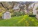 Expansive backyard with a storage shed and mature trees creating a private and serene setting at 13929 Lake Fishhawk Dr, Lithia, FL 33547