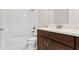 Clean bathroom with a white tile shower-tub combination, a marble countertop and dark wood cabinets at 13929 Lake Fishhawk Dr, Lithia, FL 33547