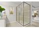 Modern bathroom with a glass enclosed shower, granite countertops, and an entrance to the bedroom at 13929 Lake Fishhawk Dr, Lithia, FL 33547