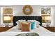 Comfortable bedroom with a stylish headboard, decorative pillows, and natural light from the surrounding windows at 13929 Lake Fishhawk Dr, Lithia, FL 33547