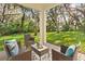 Charming covered patio with outdoor seating, perfect for relaxing and enjoying the serene backyard view at 13929 Lake Fishhawk Dr, Lithia, FL 33547