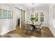 Elegant dining area featuring a modern chandelier, glass table, and access to the laundry room at 13929 Lake Fishhawk Dr, Lithia, FL 33547