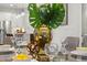 Stylish dining room with a glass table, leafy centerpiece, and views into the modern kitchen at 13929 Lake Fishhawk Dr, Lithia, FL 33547