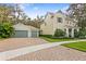 Charming two-story home with a two-car garage, lush landscaping, and brick driveway at 13929 Lake Fishhawk Dr, Lithia, FL 33547