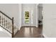 Bright foyer with hardwood floors, staircase, and a clear view through the glass front door at 13929 Lake Fishhawk Dr, Lithia, FL 33547