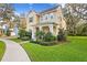 Charming two-story home featuring a welcoming front porch, manicured landscaping, and a sidewalk at 13929 Lake Fishhawk Dr, Lithia, FL 33547