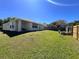 A view of the private backyard features a well-manicured lawn and a partial fence at 418 Henderson Ave, Seffner, FL 33584