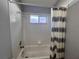 Bright bathroom features a tiled shower and tub combination with a striped shower curtain at 418 Henderson Ave, Seffner, FL 33584
