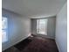 Cozy bedroom featuring neutral walls, carpet, and a large arched window at 418 Henderson Ave, Seffner, FL 33584