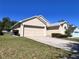 This single-Gathering home features a two-car garage, driveway, and well-kept lawn and landscaping at 418 Henderson Ave, Seffner, FL 33584
