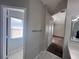 Hallway featuring neutral walls and a view into a room with tile floors and natural light at 418 Henderson Ave, Seffner, FL 33584