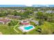 Aerial view featuring the pool area, surrounding landscaping, and community buildings in a residential neighborhood at 12200 Vonn Rd # 1209, Largo, FL 33774