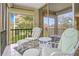 Screened-in lanai featuring tiled flooring, cushioned chairs, and a peaceful outdoor view at 12200 Vonn Rd # 1209, Largo, FL 33774