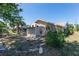 Exterior view of the backyard, including a storage shed, the home's facade, and partial view of the screened-in pool area at 181 Sportsman Rd, Rotonda West, FL 33947