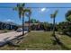 Lush lawn and mature palms frame this bright home with a paved driveway leading to the attached garage at 181 Sportsman Rd, Rotonda West, FL 33947