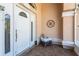 Inviting covered front porch leads to a white door, adorned with a decorative metal artwork on the wall at 181 Sportsman Rd, Rotonda West, FL 33947