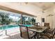 Covered patio with seating area overlooking the screened-in pool, ideal for outdoor dining and relaxation at 181 Sportsman Rd, Rotonda West, FL 33947