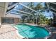 Sparkling swimming pool within a screened enclosure, featuring a brick patio and access to outdoor living spaces at 181 Sportsman Rd, Rotonda West, FL 33947