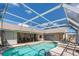 Inviting screened-in pool with attached spa, offering a relaxing backyard oasis for leisure and recreation at 181 Sportsman Rd, Rotonda West, FL 33947