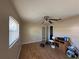 Bedroom with hardwood floors, a ceiling fan, and natural light from a large window at 6312 Fairway Blvd, Apollo Beach, FL 33572