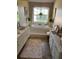 Bathroom with a large tub, tile floor, and a window providing natural light at 4041 Murfield E Dr, Bradenton, FL 34203