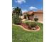 This home boasts a lush landscaped yard with colorful flowers, a paver driveway, and a tile roof at 4041 Murfield E Dr, Bradenton, FL 34203