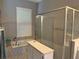 Bathroom features soaking tub, glass enclosed shower with tile, and window with shutters at 4749 Stoneview Cir, Oldsmar, FL 34677
