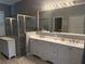 Large bathroom featuring double sink vanity, glass shower, and a separate door at 4749 Stoneview Cir, Oldsmar, FL 34677