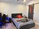 Modern bedroom with a sleek black bed, dark barn door, and contemporary decor at 4749 Stoneview Cir, Oldsmar, FL 34677