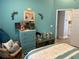 Charming bedroom featuring turquoise walls, nautical decorations, and view to ensuite bathroom at 4749 Stoneview Cir, Oldsmar, FL 34677